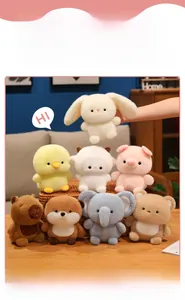 Close-up of soft plush animal dolls including capybara and sheep on a wooden desk