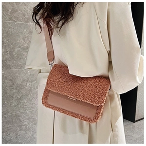 Detail view of pink teddy fur crossbody bag on model wearing a beige trench coat