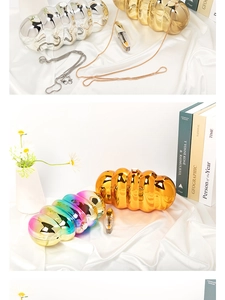 Macro shot of stylish cloud-shaped acrylic bags with metallic finish and delicate chains