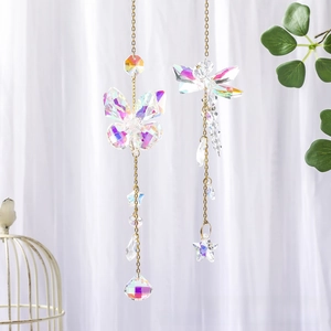 Close-up of golden butterfly and dragonfly suncatchers with sparkling crystal prisms