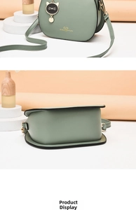 Detail showing sage green saddle bag with gold heart text and a black cat charm