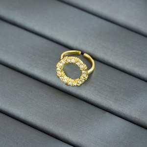 Macro detail of gold plated open ring featuring a circular design with white zircons
