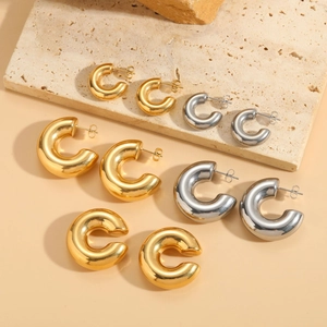 Detail showing various sizes of polished C-shape hoop earrings in gold and silver finish