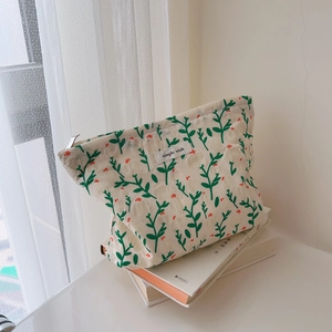 Detailed texture of floral cotton makeup bag with simple wish label and metal zipper