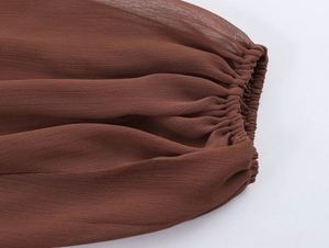Close-up of elastic ruffled cuffs on long chiffon bohemian dress in dark brown