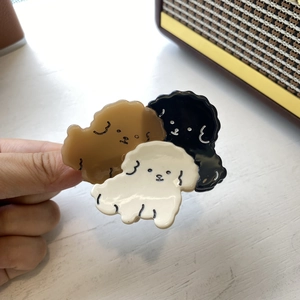 Detailed close-up of a tricolor poodle acetate hair claw clip in brown, black and cream