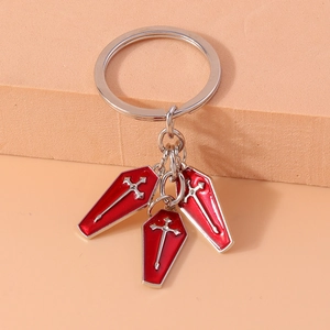 Macro shot of gothic keychain with three red enamel coffin pendants and silver sword motifs