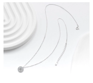 Macro shot of S925 sterling silver necklace with sparkling round zircon pendant on white background