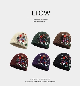 Détail de boutons décoratifs colorés sur un bonnet d'hiver en tricot disponible en six coloris