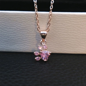 Macro shot of rose gold necklace with pink heart-shaped pet paw print pendant