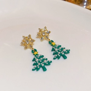 Detail of Christmas tree drop earrings with gold snowflake studs and white pearls