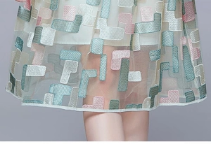 Close-up of heavy embroidery on mesh dress with pastel geometric patterns