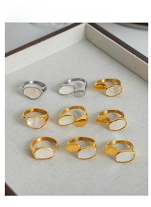 Macro detail of gold plated steel rings featuring iridescent oval mother of pearl inlays