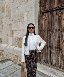 Chic women's white cropped jacket with stylish buttons and leopard print trousers outfit