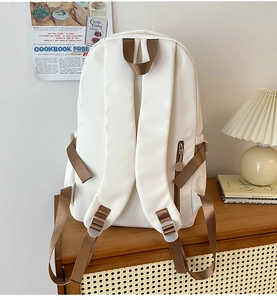 Rear view of white ergonomic school backpack with wide brown straps and side zipper pocket