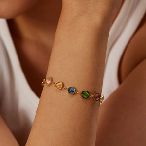 Gros plan d'un bracelet en acier inoxydable doré 18 carats avec pierres œil de chat colorées