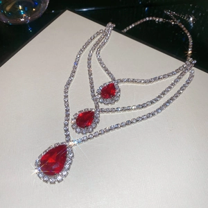 Dettaglio macro della collana argento a tre strati con pietre rosse a goccia