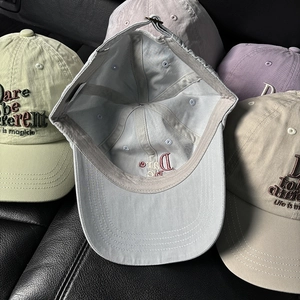 Collection of washed cotton baseball caps with 3D embroidery on a leather surface