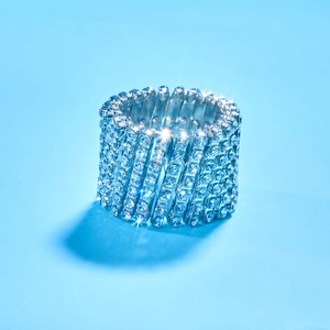 Silver stretch ring bracelet with seven rows of crystals on light blue background