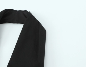 Close-up of the woven texture on a black halter neck strap with refined fabric detail