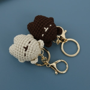 Mini hand-knitted bear keychains in brown and beige colors with metal accessories