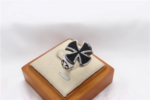 Macro shot of silver titanium steel ring with black enamel maltese cross and side details