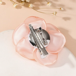 Detailed back view of pink fabric rose brooch with silver metal duckbill clip