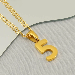 Close-up of golden stainless steel number 5 pendant with polished metal chain link