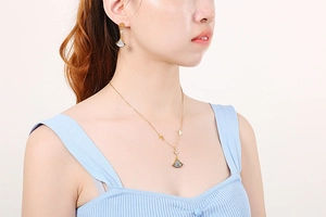 Detailed view of fan-shaped crystal necklace and earrings set on a female model