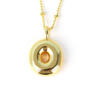 Detailed view of a thick gold donut pendant on a beaded chain necklace for men and women