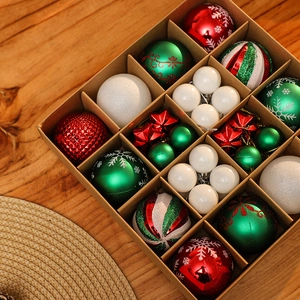 Assorted red, green, and white Christmas ornaments in a partitioned kraft gift box