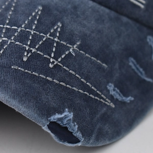 Detail of vintage navy cotton baseball cap with distressed brim and white stitching