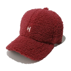 Gros plan détaillé sur la casquette en laine d'agneau bordeaux avec broderie H blanche