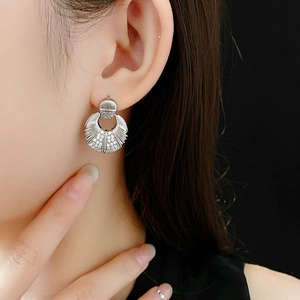 Vue macro de boucles d'oreilles argentées en forme de coquille avec des zircons