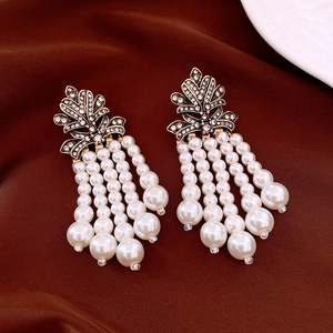 Détails de boucles d'oreilles vintage dorées avec pampilles en perles et strass brillants