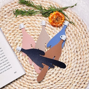 Flat lay of multiple leather spilled coffee bookmarks in five colors on a woven mat