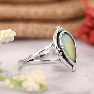 Vue macro de la bague vintage argentée avec anneau fendu et opale irisée ovale