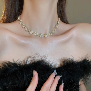 Gros plan du collier choker doré champagne avec zircons blancs étincelants sur modèle