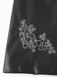 Detail of black PU leather dress featuring intricate silver beaded floral embroidery on hem
