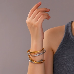 Minimalist 18k gold plated stainless steel wave bangle with a stylish irregular C-shaped design