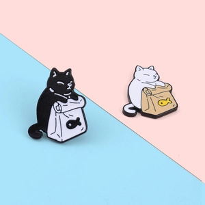 Close-up of cute black and white alloy cat enamel pins on pastel background
