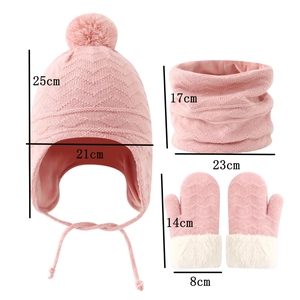 Détail d'un ensemble d'hiver rose pour bébé avec bonnet tricoté, écharpe et gants