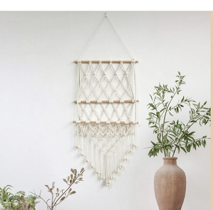 Detail of bohemian hand-woven cotton macrame storage net with tassels and wood beads