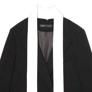 Minimalist black blazer for women featuring a unique white contrast scarf lapel and brand label