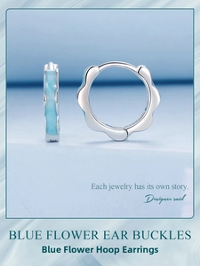 Detail of flower shaped silver hoop earrings with sky blue enamel wave borders