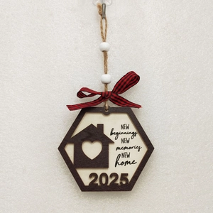 Detail of a 2025 wooden housewarming ornament with heart motifs and a red plaid bow