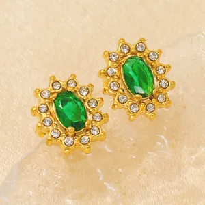 Luxurious gold sunburst stud earrings featuring a green oval gemstone and white crystals