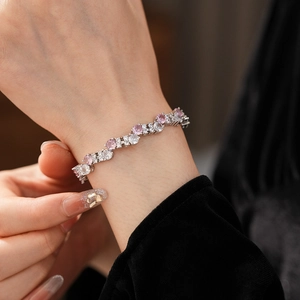 Detail of elegant silver bracelet with pink and white cubic zirconia on wrist