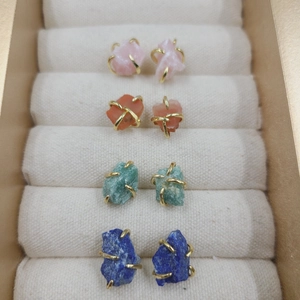 Macro detail of natural raw crystal stud earrings in four colors on velvet display