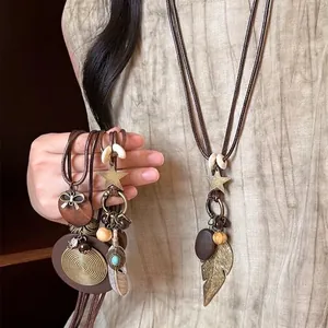 Ethnic bohemian long sweater necklace with wooden pendant, feather charms and star details